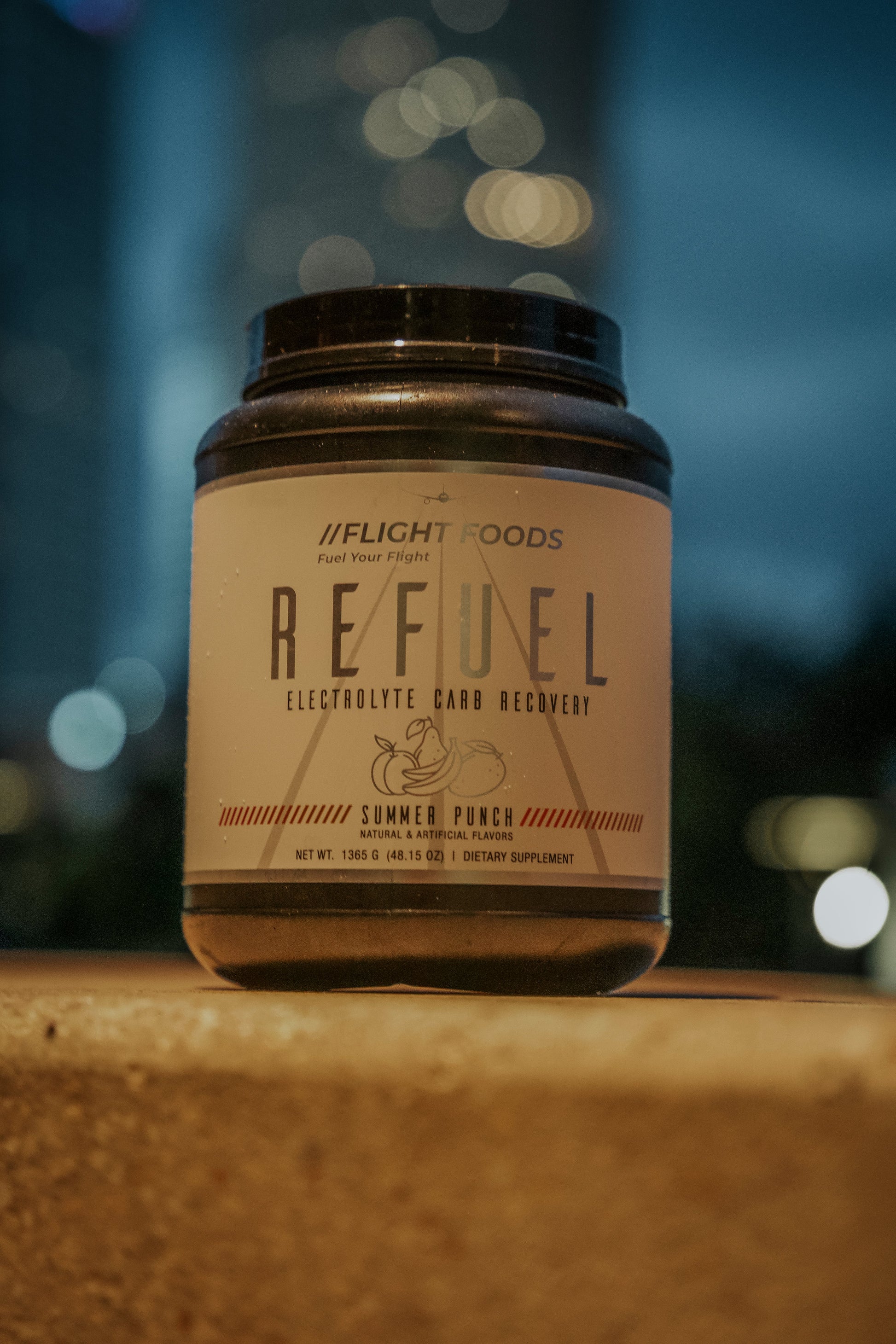 Refuel Electrolyte Carb Recovery Blend in Summer Punch flavor displayed against a New York City backdrop